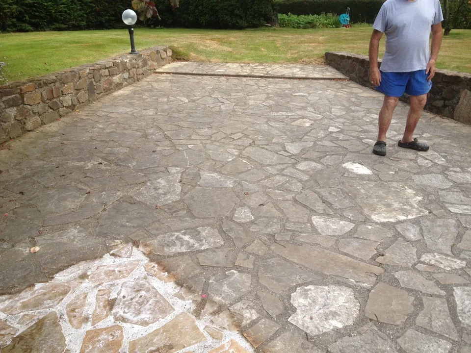 Terrasse présentant des traces entre deux murets de pierre, avec une personne
